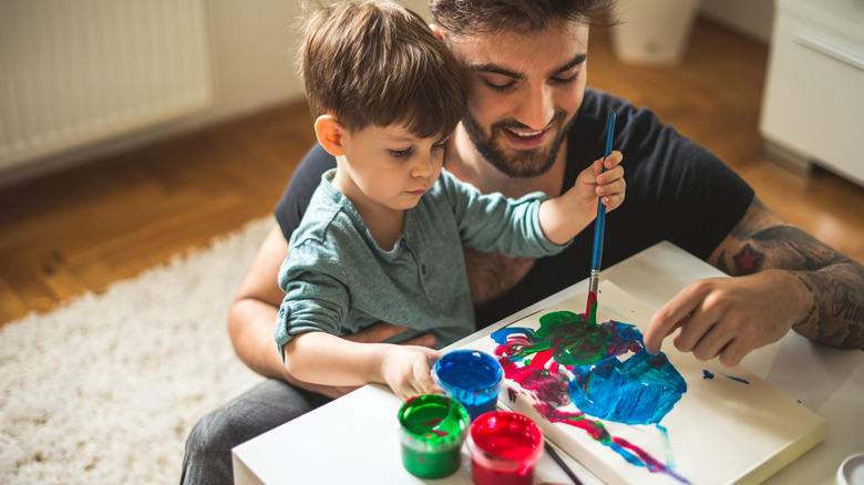 Father and son painting together at home