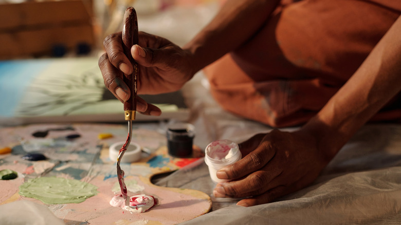 Artist mixing paint on a palette