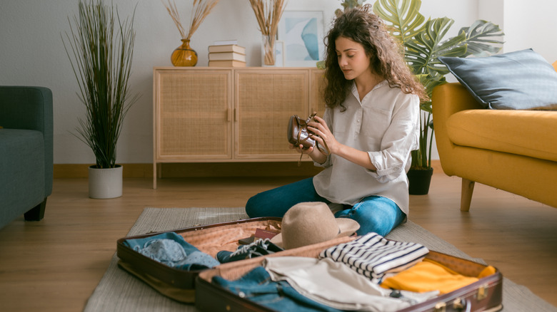 Woman packing suitcase at home