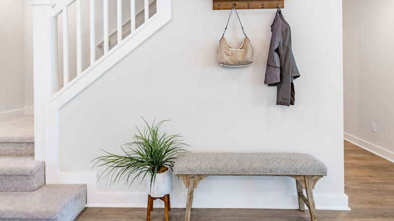 Small entryway with a compact padded bench for seating