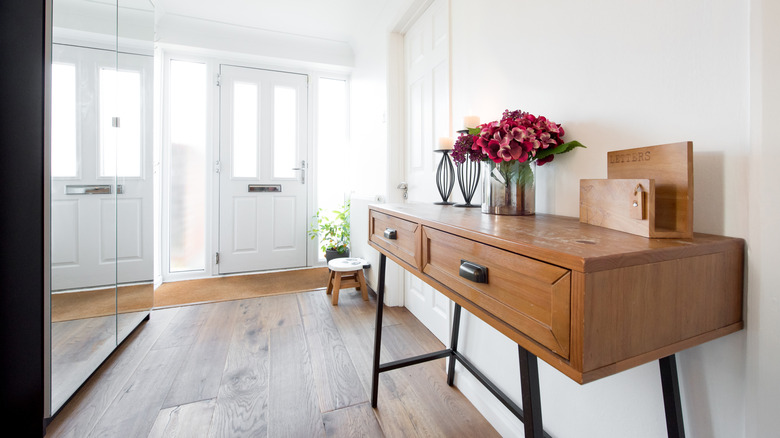 Entryway with wooden console table with drawers and decorations