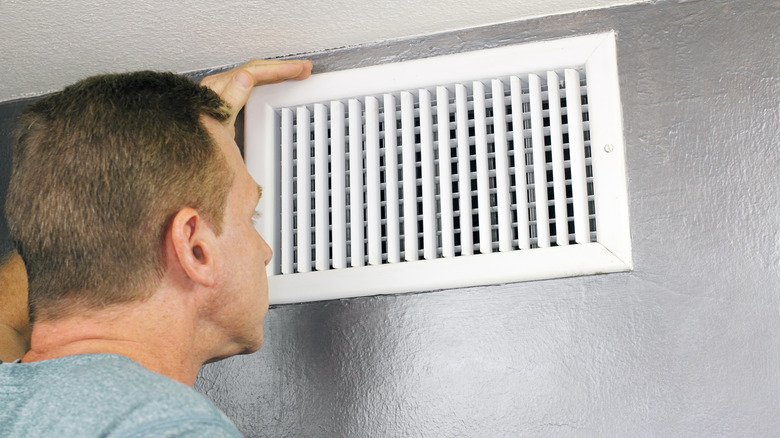 Technician examining air duct