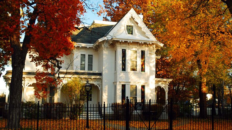 charming white house red foliage 