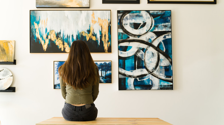 A woman looks at art in a gallery.