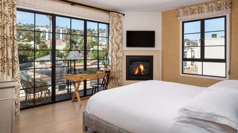 white bed in modern room with fire place