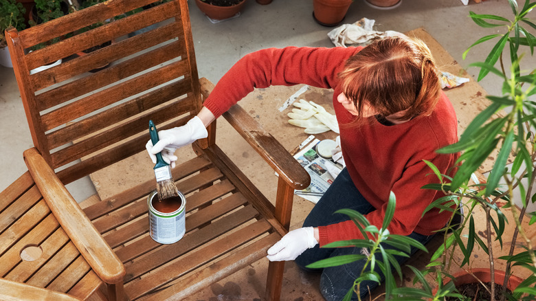 Woman staining a wooden chair