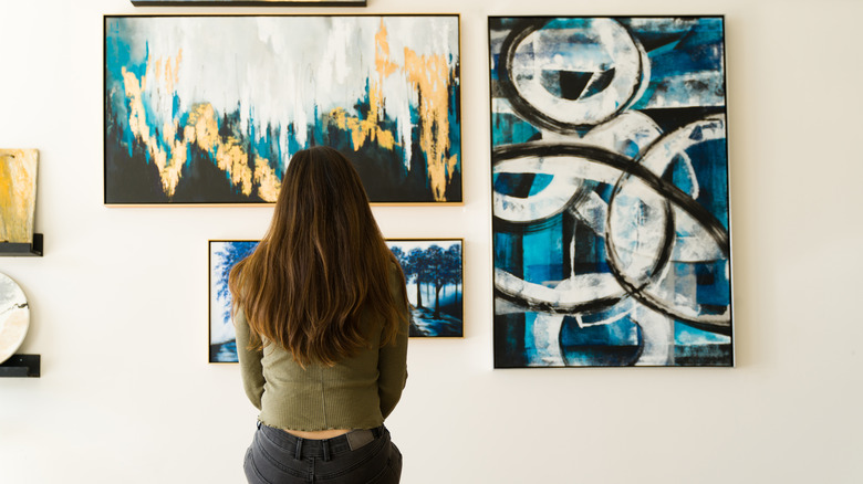 person looking at wall art 