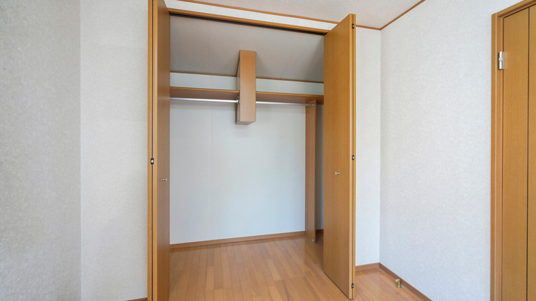 Open wooden bifold doors showing empty closet