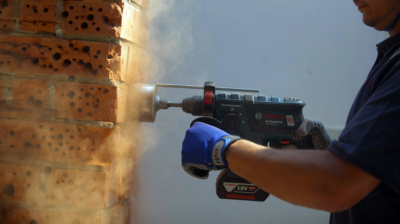 An employee testing a Bosch cordless rotary hammer drill