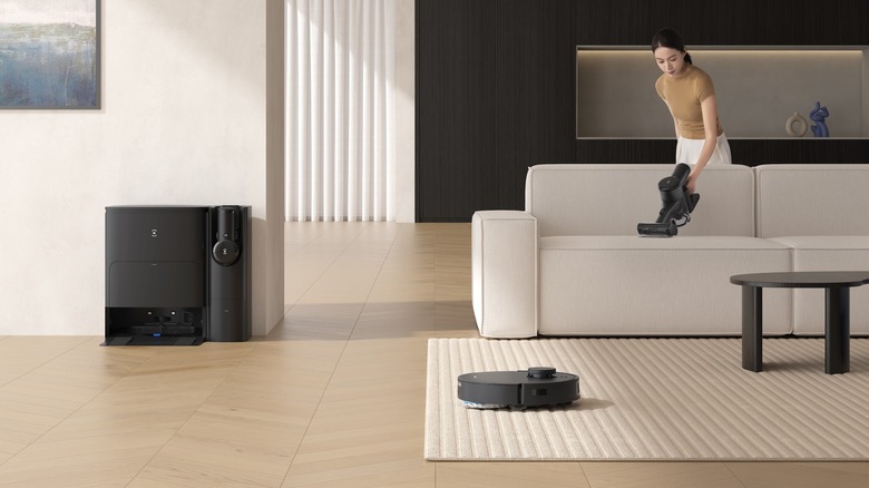 A woman cleaning her couch with an ECOVACS vacuum