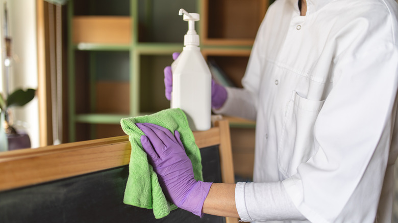 person cleaning chalkboard