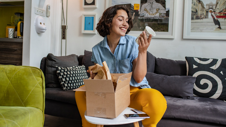 woman happily holds vase