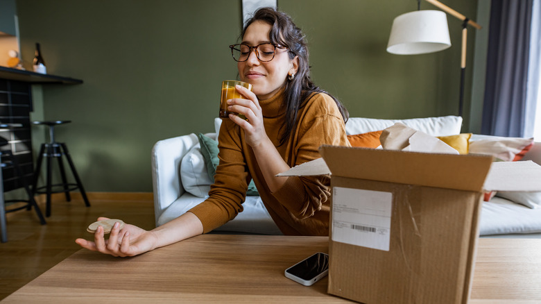 woman happily smelling candle