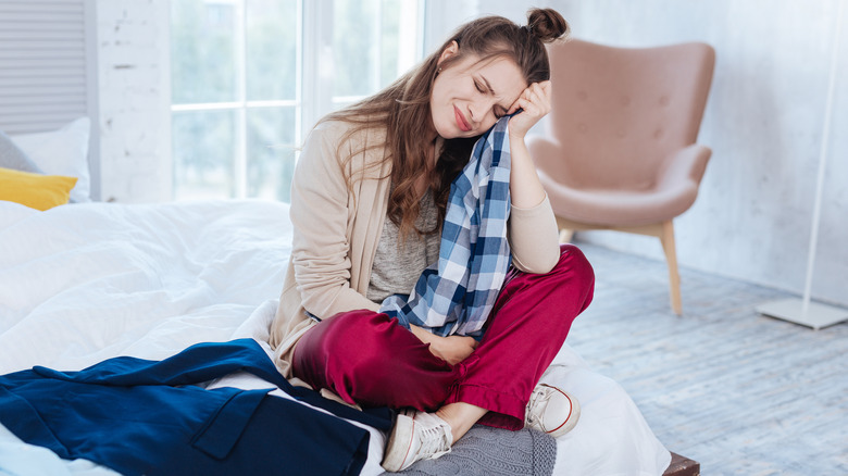 upset woman holding shirt