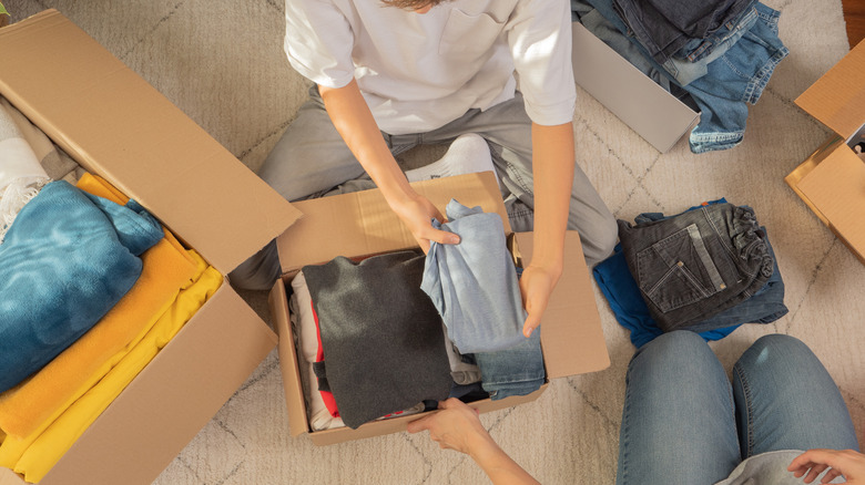 Two people packing a box