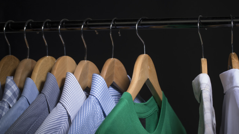 Dark closet with men's shirts hanging