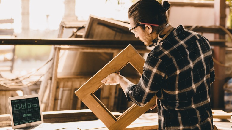 person with wood window frame