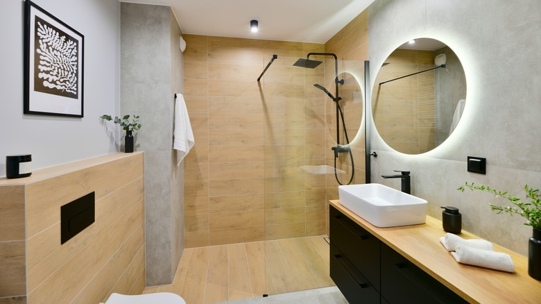 A modern small bathroom with a walk-in shower inside an open glass enclosure