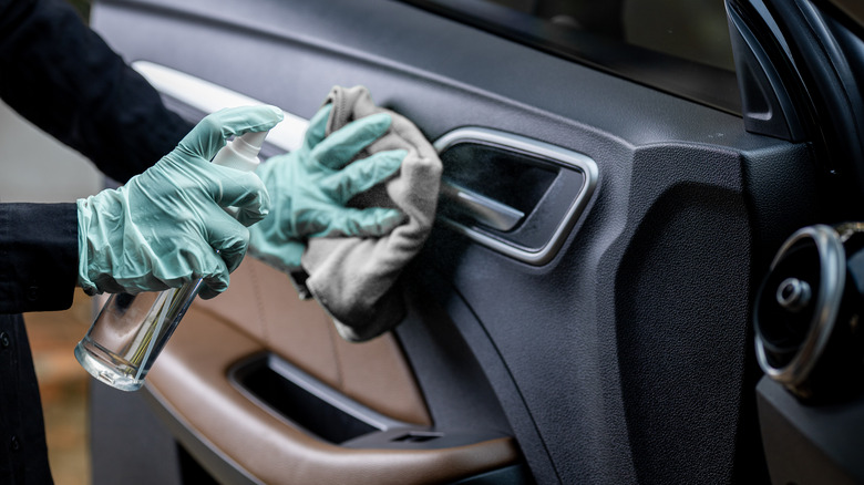 person cleaning car door