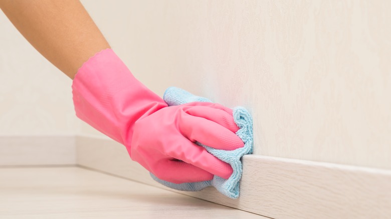 person cleaning baseboards