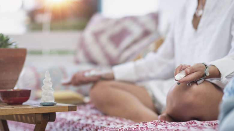 person meditating with crystals