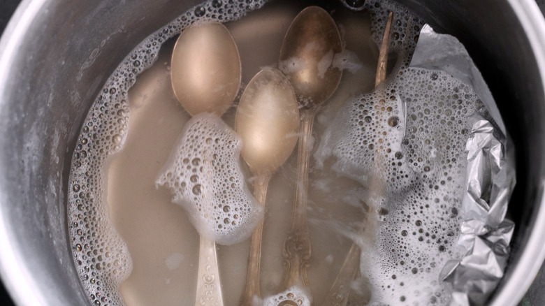 tarnished silverware soaking in water