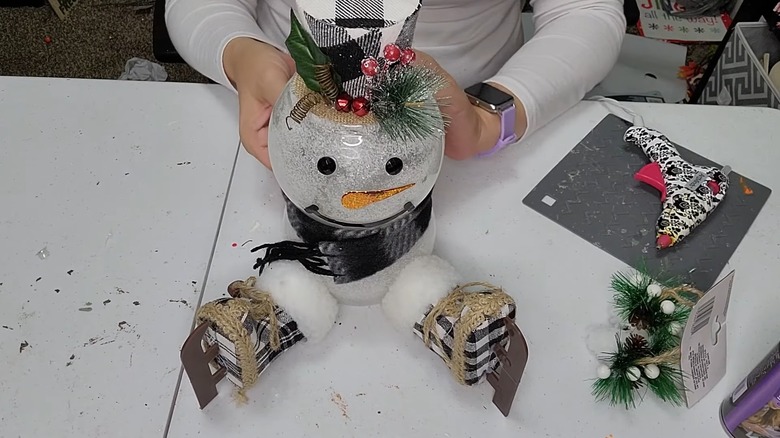 DIY snowman with ice skates, scarf, and top hat