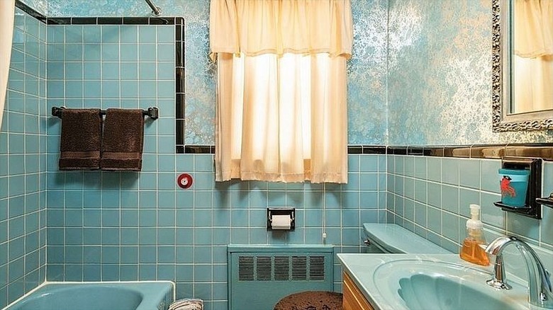 Bathroom with blue tile and metallic floral wallpaper