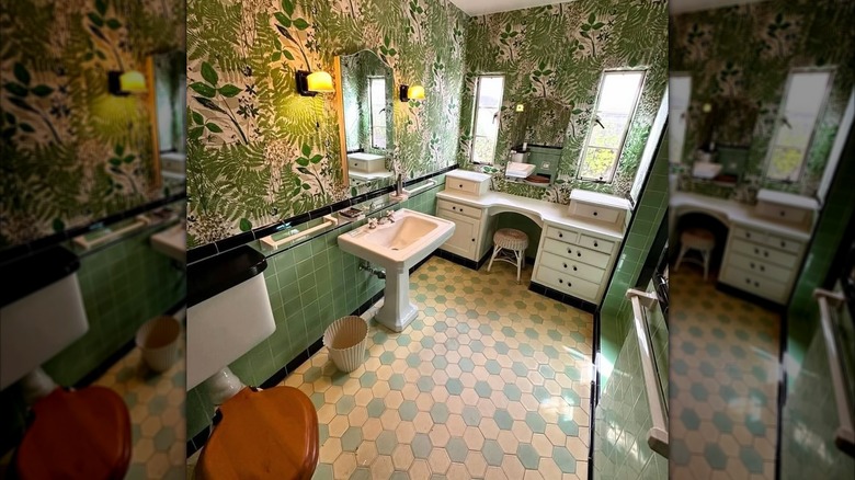 Bathroom with green tile and tropical wallpaper