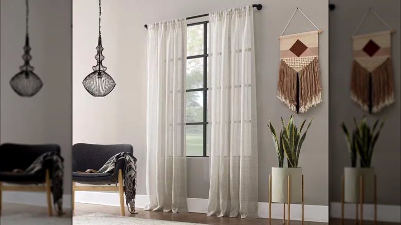 Linen curtains hang in a boho style living room