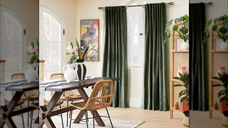 Green velvet curtains hang in a stylish dining room