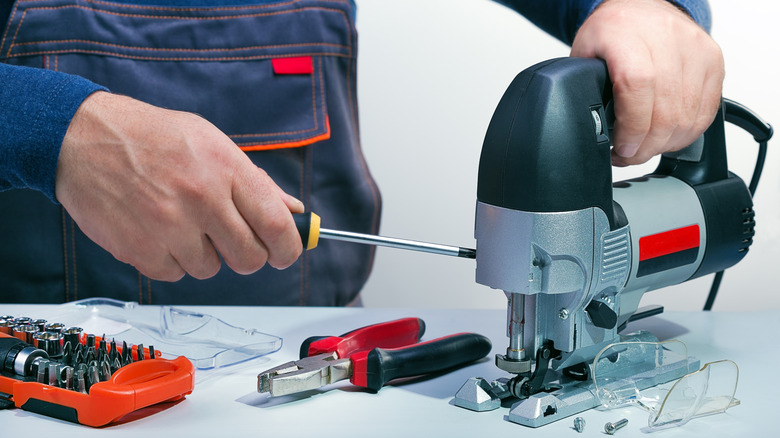 Technician repairing an electric jigsaw