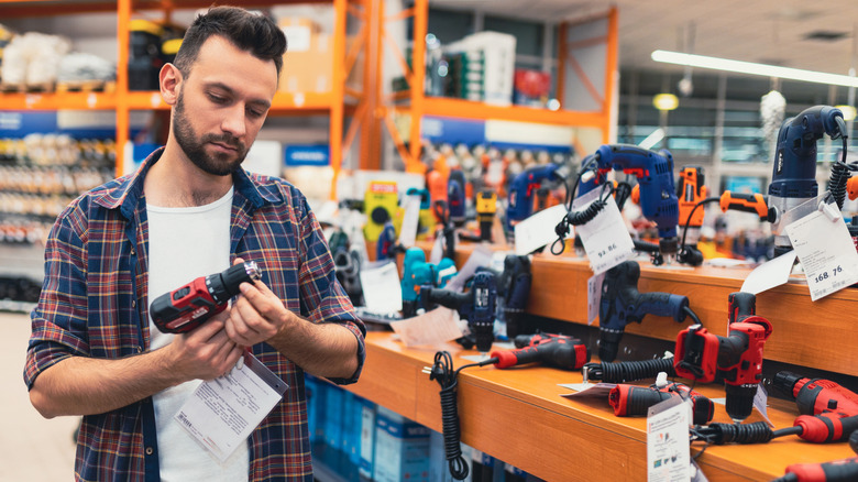 A man checking out a power tool in a store