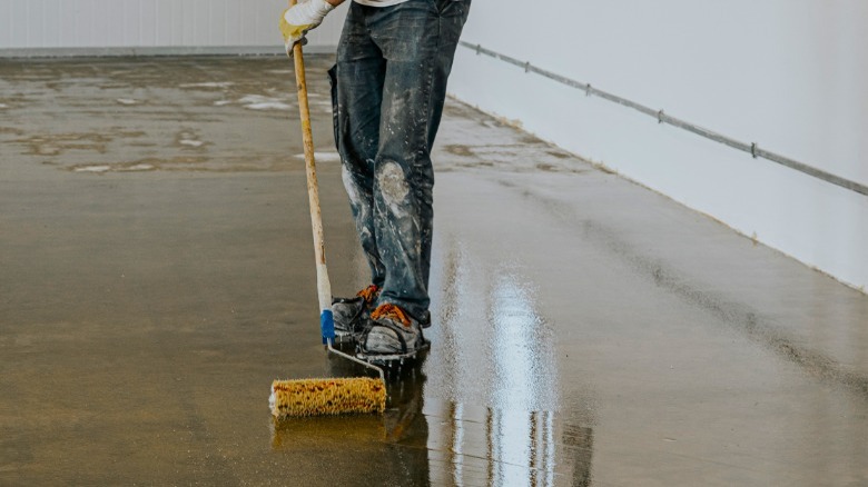 Worker coating floor with epoxy