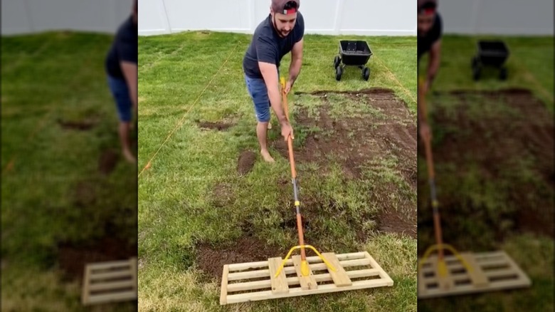 man using wooden leveling rake