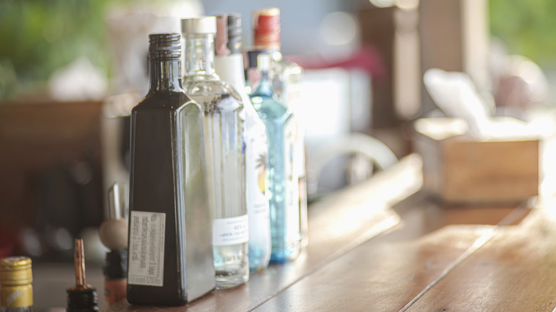 Several bottles of various types of alcohol on a counter.