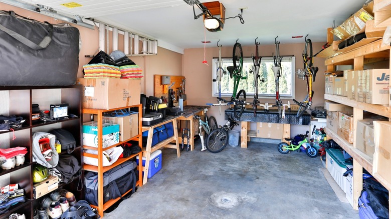 An organized garage with shelving, workbenches, and suspended bicycles