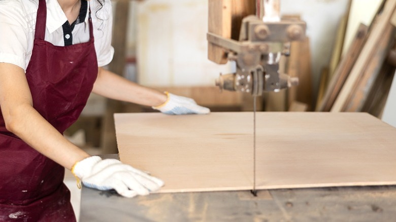 woman sawing plywood panel