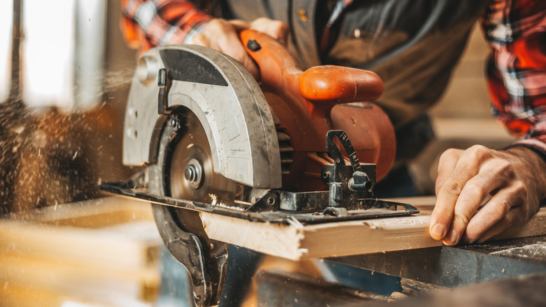 A person cutting lumber with a circular saw