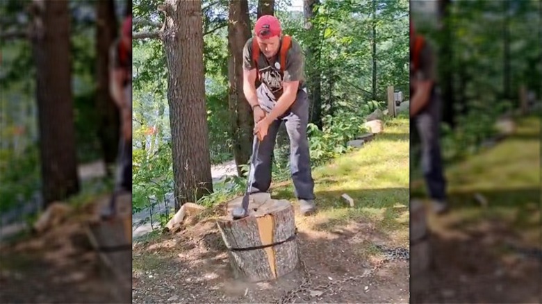 man splitting wood with axe