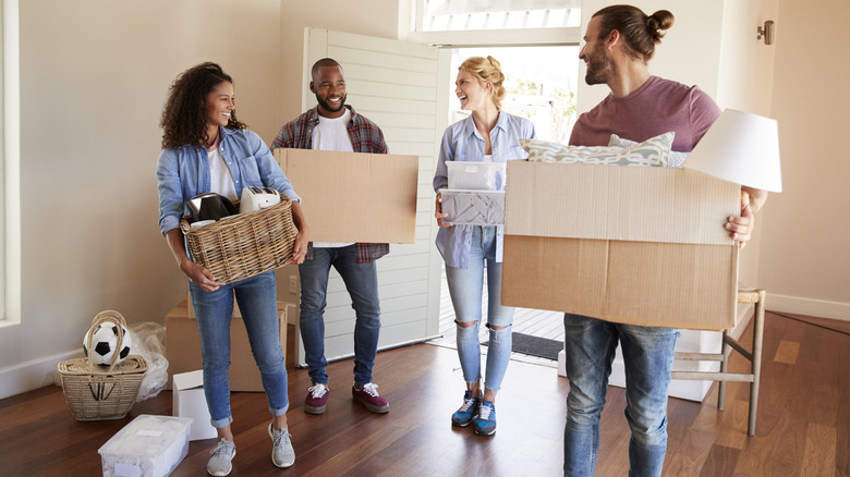 Group moving belongings into house