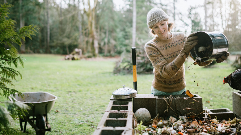 Woman adds scraps to compost 