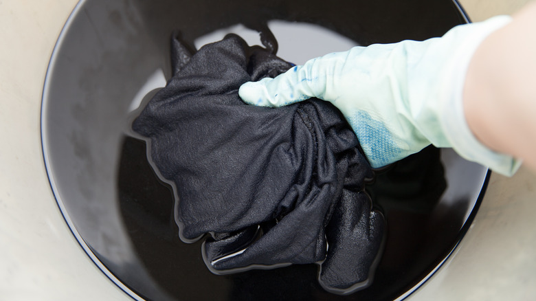 Person holding soaking black garment