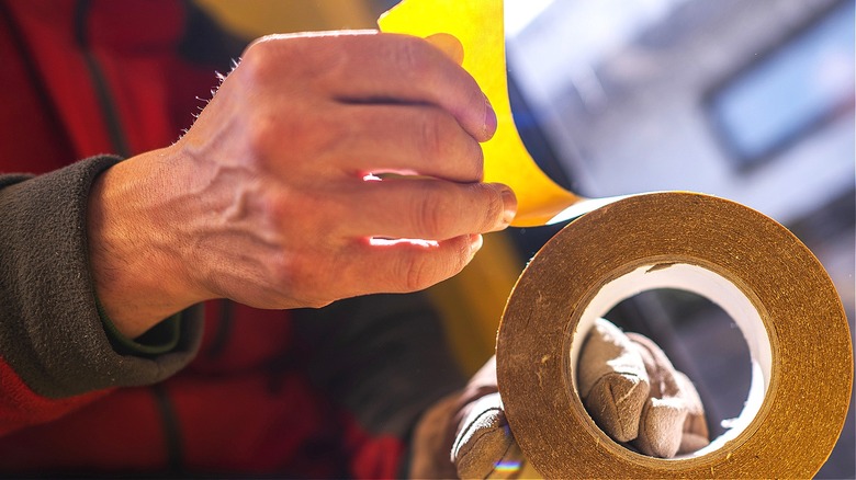 person pulling double-sided tape