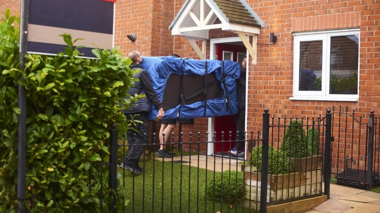 People carrying a door inside 