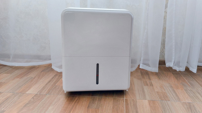 White dehumidifier on wooden floor