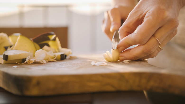 Person slicing garlic clove