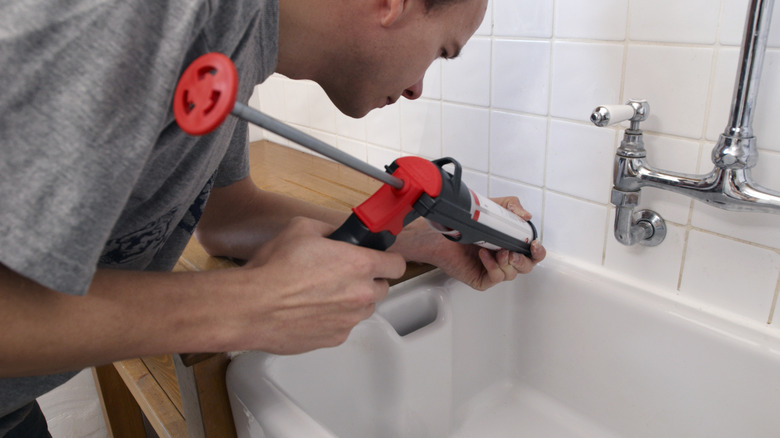 person applying silicone caulk