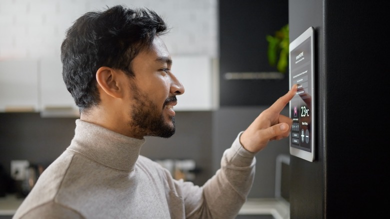 Man turning on thermostat