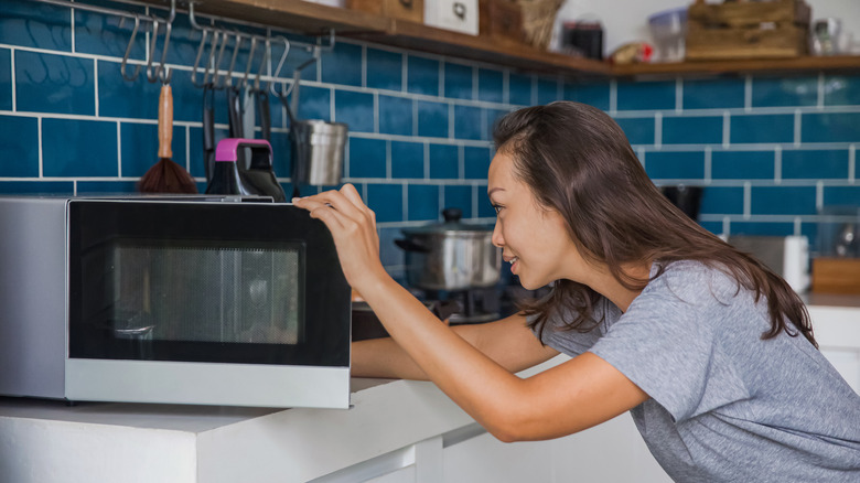 Woman using microwave